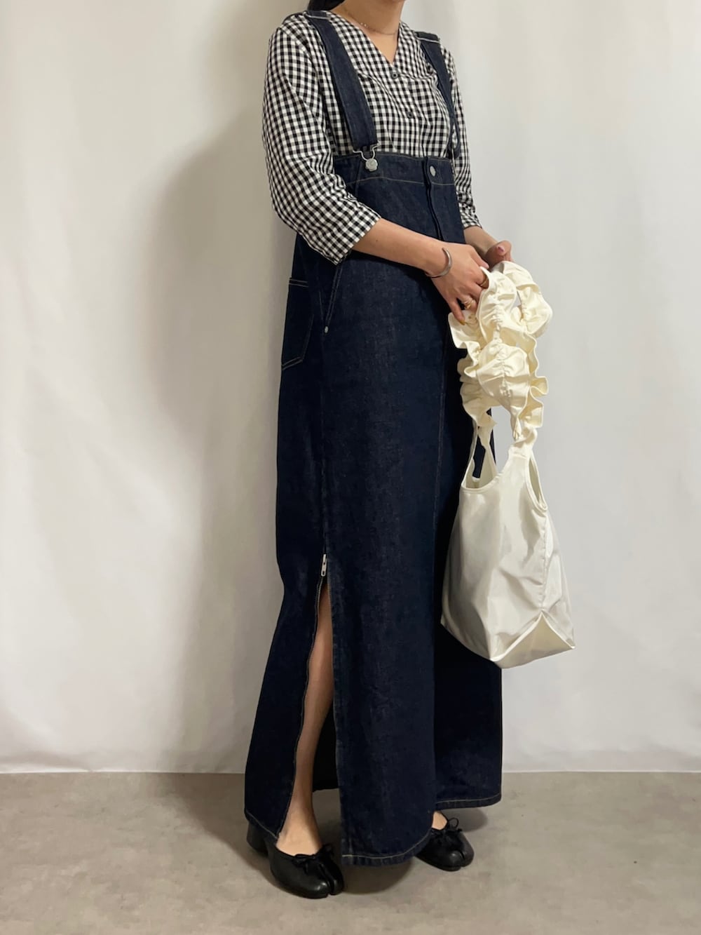 ベージュ系のトレンチコート、ブルー系のデニムスカート、ブラック系のパンプスを着用したレディースの春コーディネートの2枚目の写真