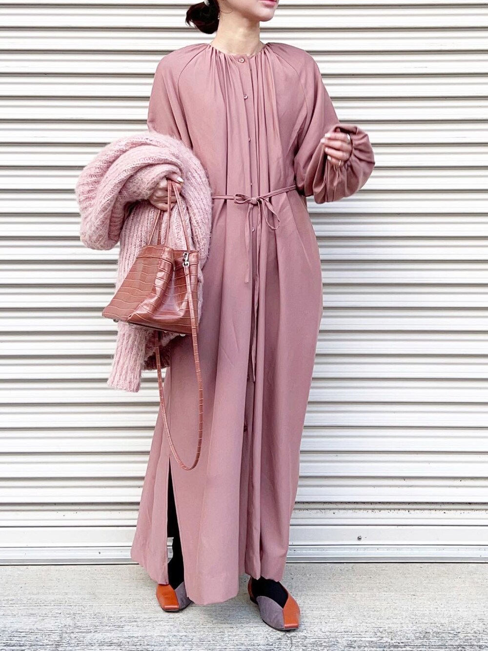 ピンク系のカーディガン/ボレロ、ピンク系のワンピース、オレンジ系のシューズを着用したレディースの春コーディネートの2枚目の写真