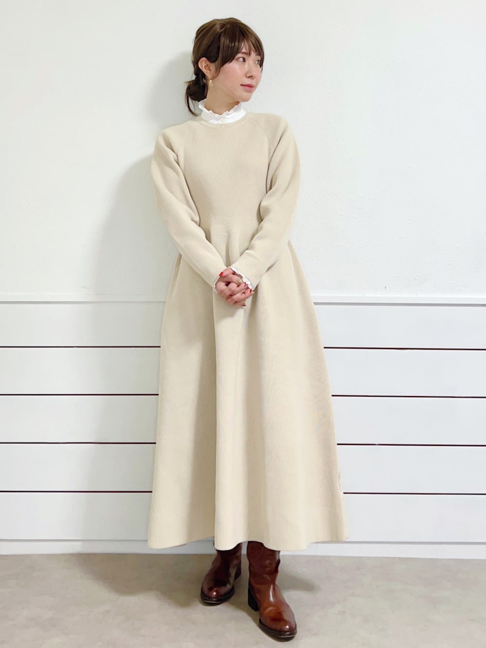 ブラウン系のチェスターコート、ブラウン系のブーツ、ベージュ系のワンピースを着用したレディースの冬コーディネートの3枚目の写真