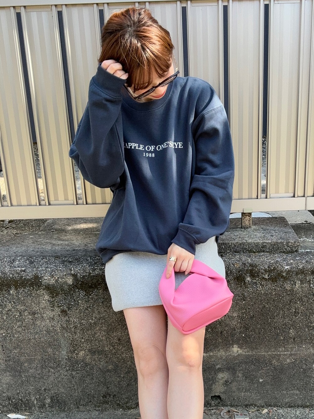 ピンク系のハンドバッグ、グレー系のスニーカー、ブルー系のスウェットを着用したレディースの秋コーディネートの3枚目の写真