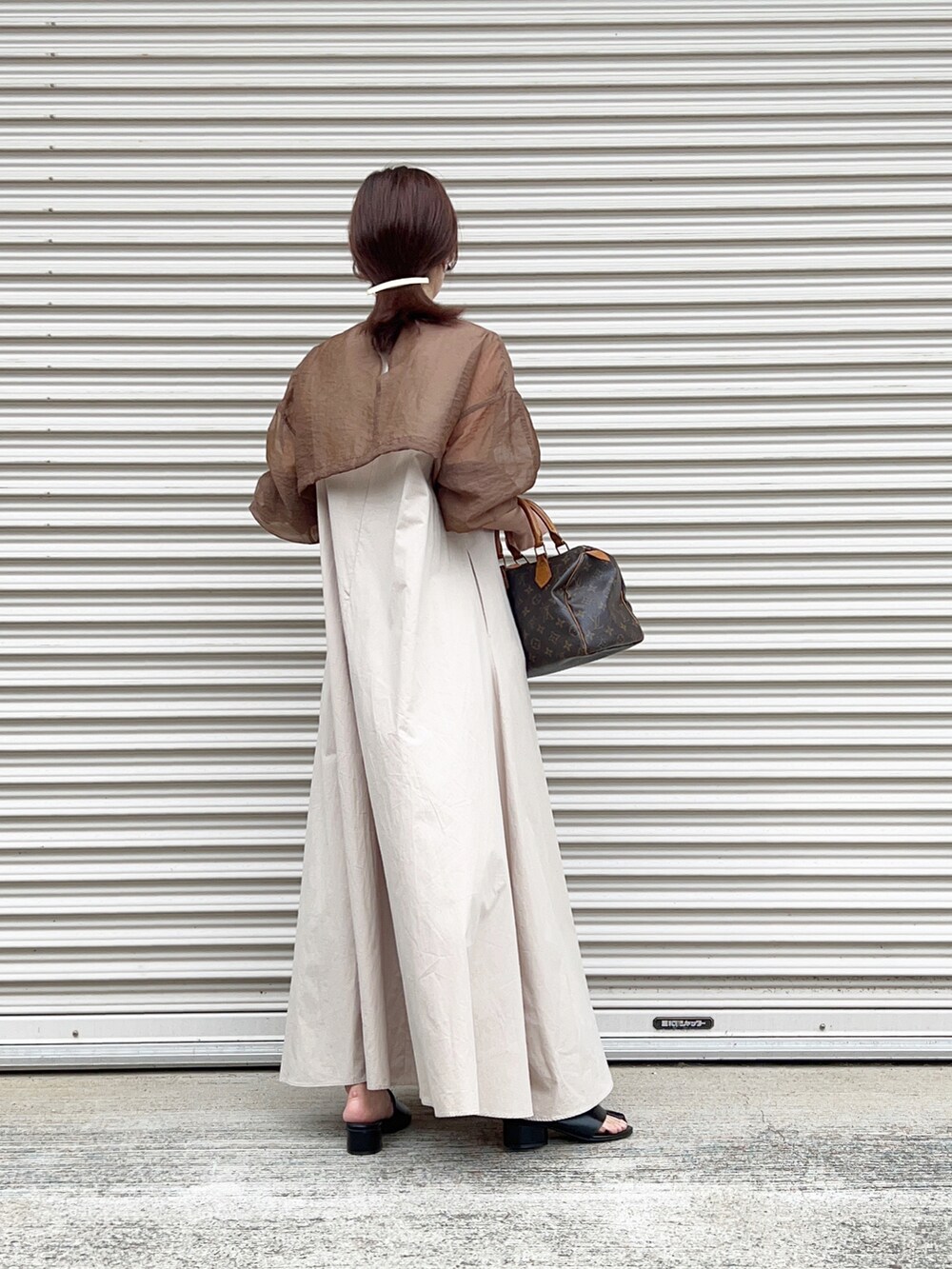 ブラウン系のシャツ/ブラウス、ベージュ系のワンピース、ブラック系のサンダルを着用したレディースの春コーディネートの2枚目の写真