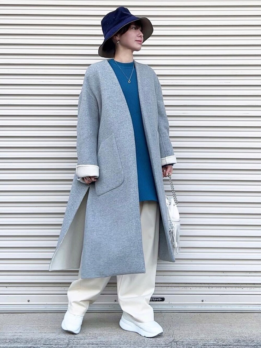 ホワイト系のスラックス、ホワイト系のスニーカー、ホワイト系のショルダーバッグを着用したレディースの春コーディネートの2枚目の写真