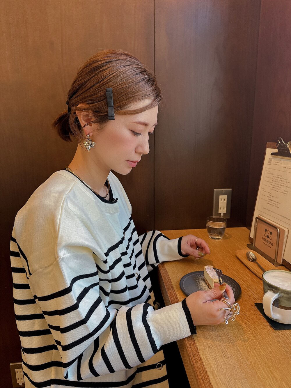 ブラック系のスニーカー、ブラック系のワンピース、その他のカーディガン/ボレロを着用したレディースの春コーディネートの2枚目の写真