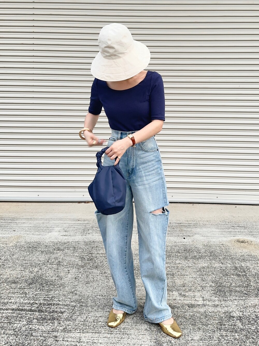 ゴールド系のバレエシューズ、ブルー系のデニムパンツ、ブルー系のTシャツ/カットソーを着用したレディースの夏コーディネートの2枚目の写真