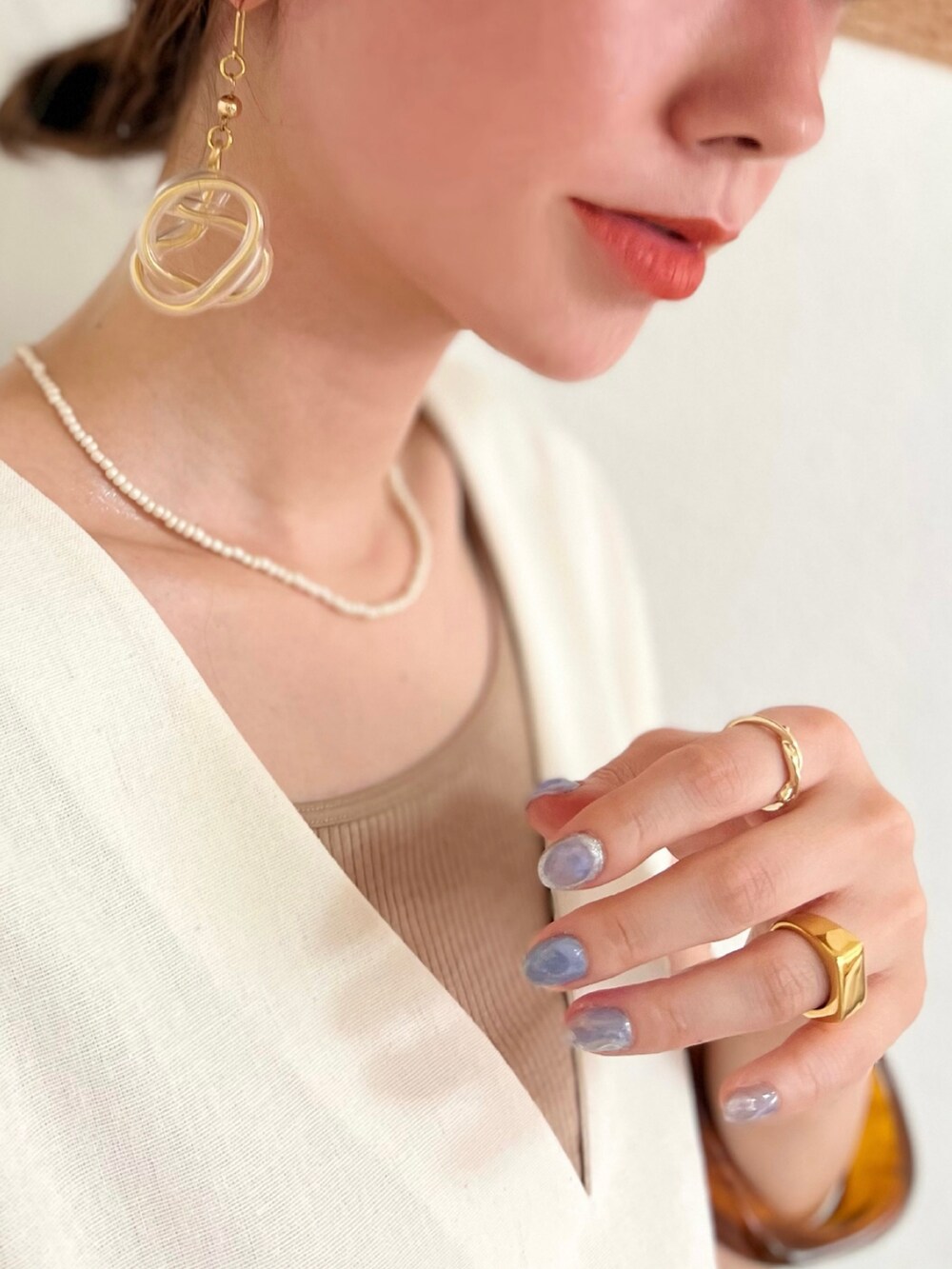 ホワイト系のベスト、ベージュ系のタンクトップ、イエロー系のトップスを着用したレディースの夏コーディネートの2枚目の写真