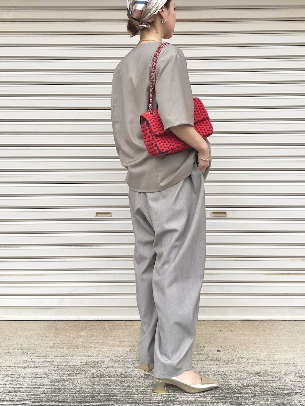 ベージュ系のスラックス、ゴールド系のパンプス、ベージュ系のノーカラージャケットを着用したレディースの秋コーディネートの3枚目の写真