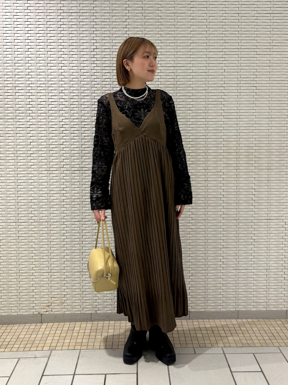 ベージュ系のショルダーバッグ、ブラック系のシャツ/ブラウス、ブラウン系のワンピースを着用したレディースの冬コーディネートの2枚目の写真