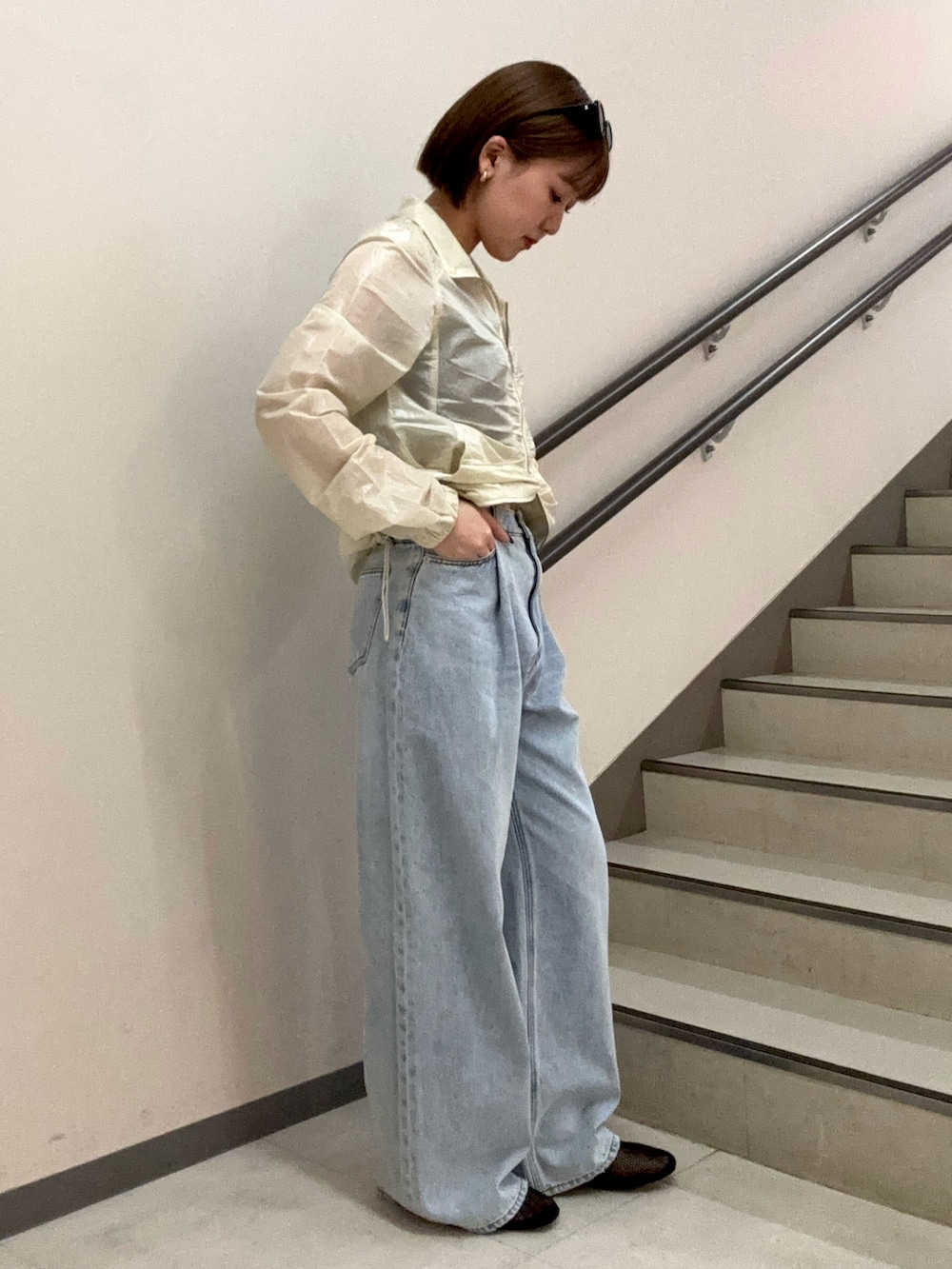 ブルー系のデニムパンツ、ブラック系のキャミソール、ホワイト系のブルゾンを着用したレディースの春コーディネートの3枚目の写真