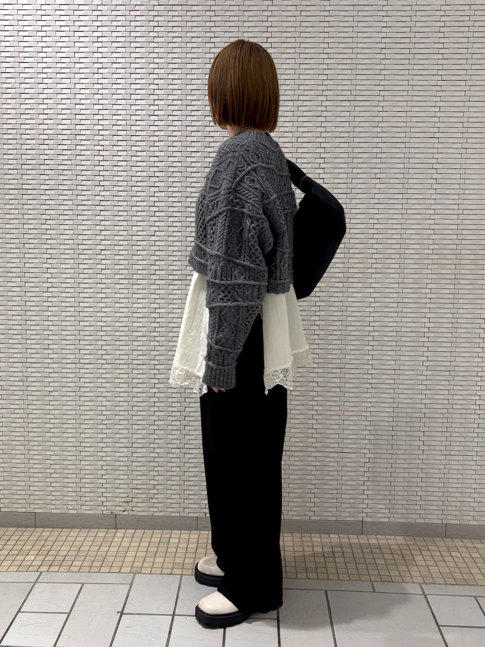 ホワイト系のキャミソール、ブラック系のその他パンツ、ブラック系のショルダーバッグを着用したレディースの冬コーディネートの5枚目の写真