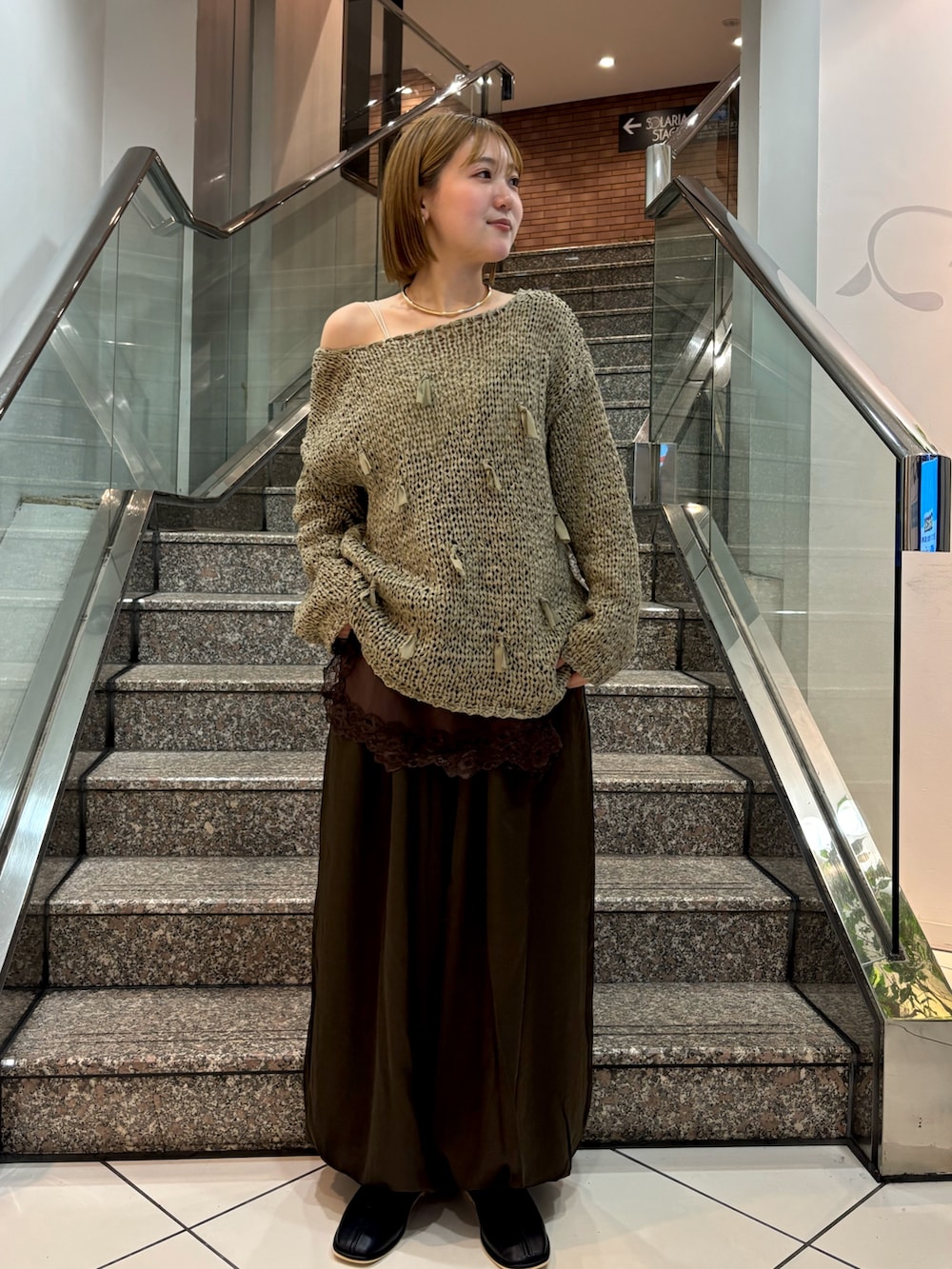 ホワイト系のキャミソール、グリーン系のニット/セーター、ブラウン系のキャミソールを着用したレディースの冬コーディネートの3枚目の写真