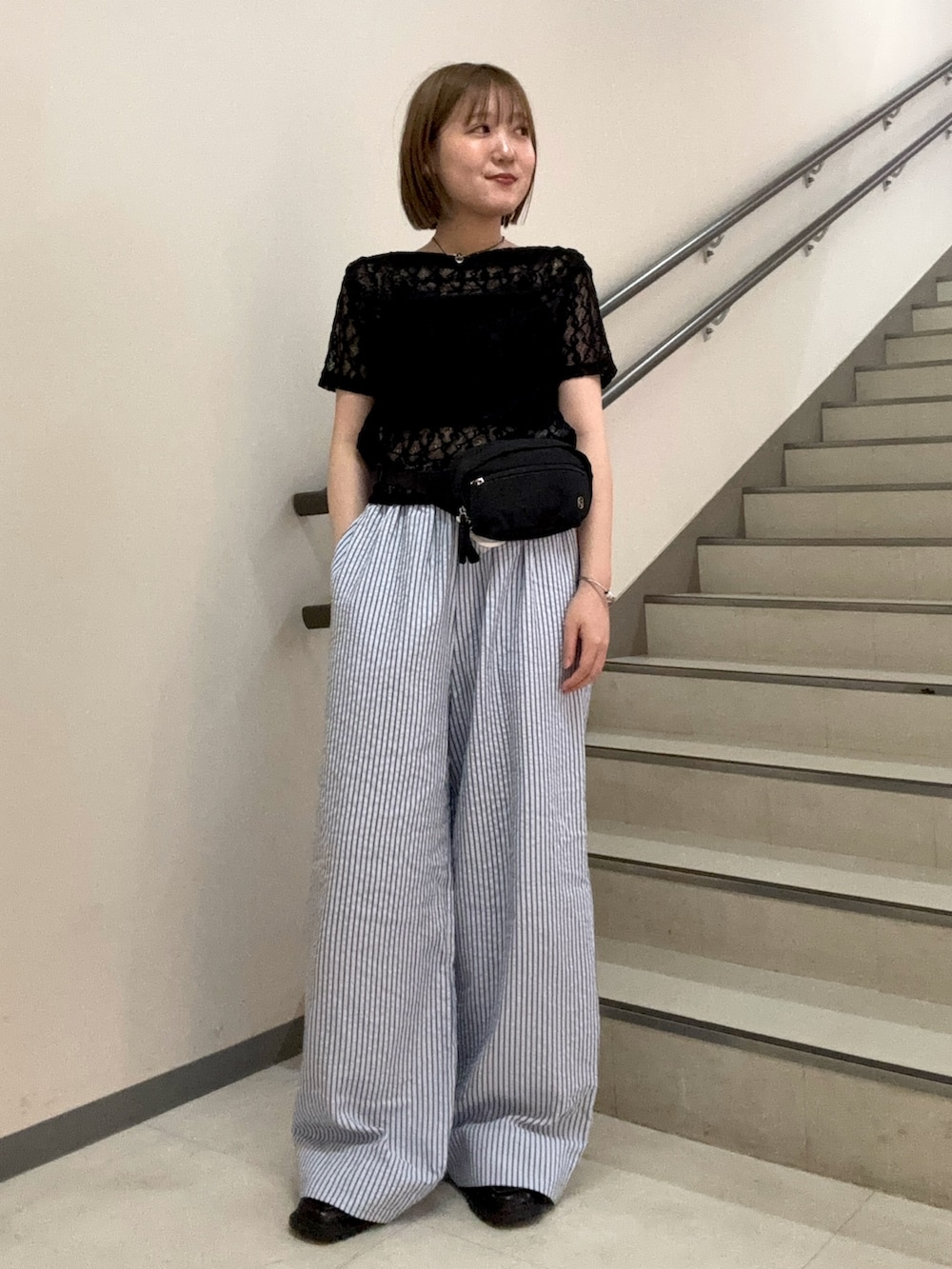 ブラック系のTシャツ/カットソー、ブラック系のボディバッグ/ウエストポーチ、ブルー系のその他パンツを着用したレディースの夏コーディネートの2枚目の写真