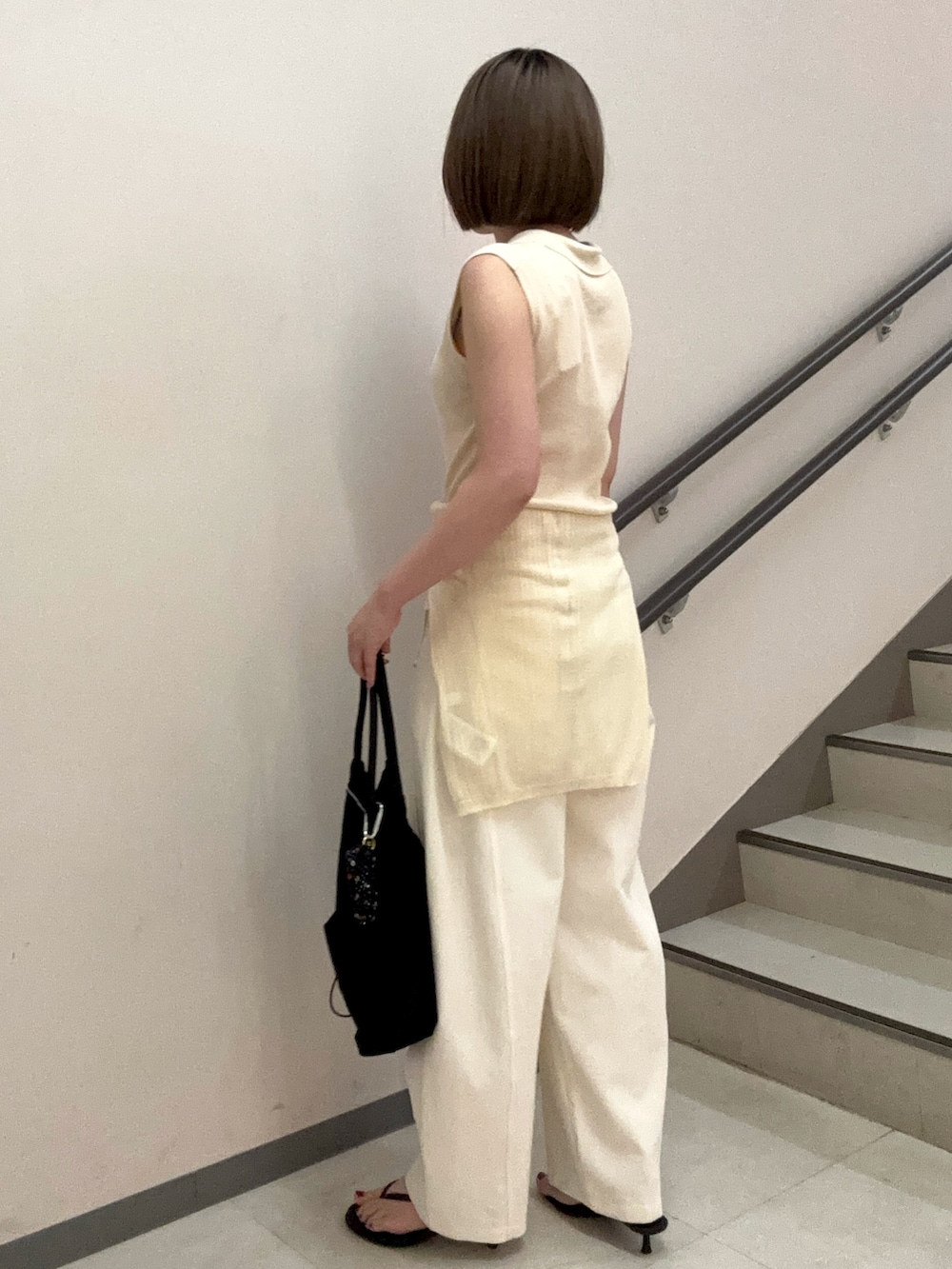 ホワイト系のその他パンツ、ブラック系のトートバッグ、ホワイト系のニット/セーターを着用したレディースの夏コーディネートの5枚目の写真
