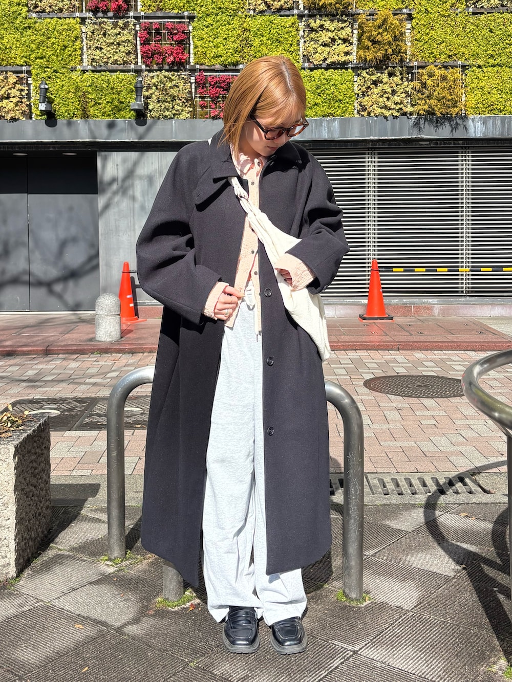 ピンク系のシャツ/ブラウス、グレー系のその他パンツ、ブラック系のステンカラーコートを着用したレディースの冬コーディネートの4枚目の写真