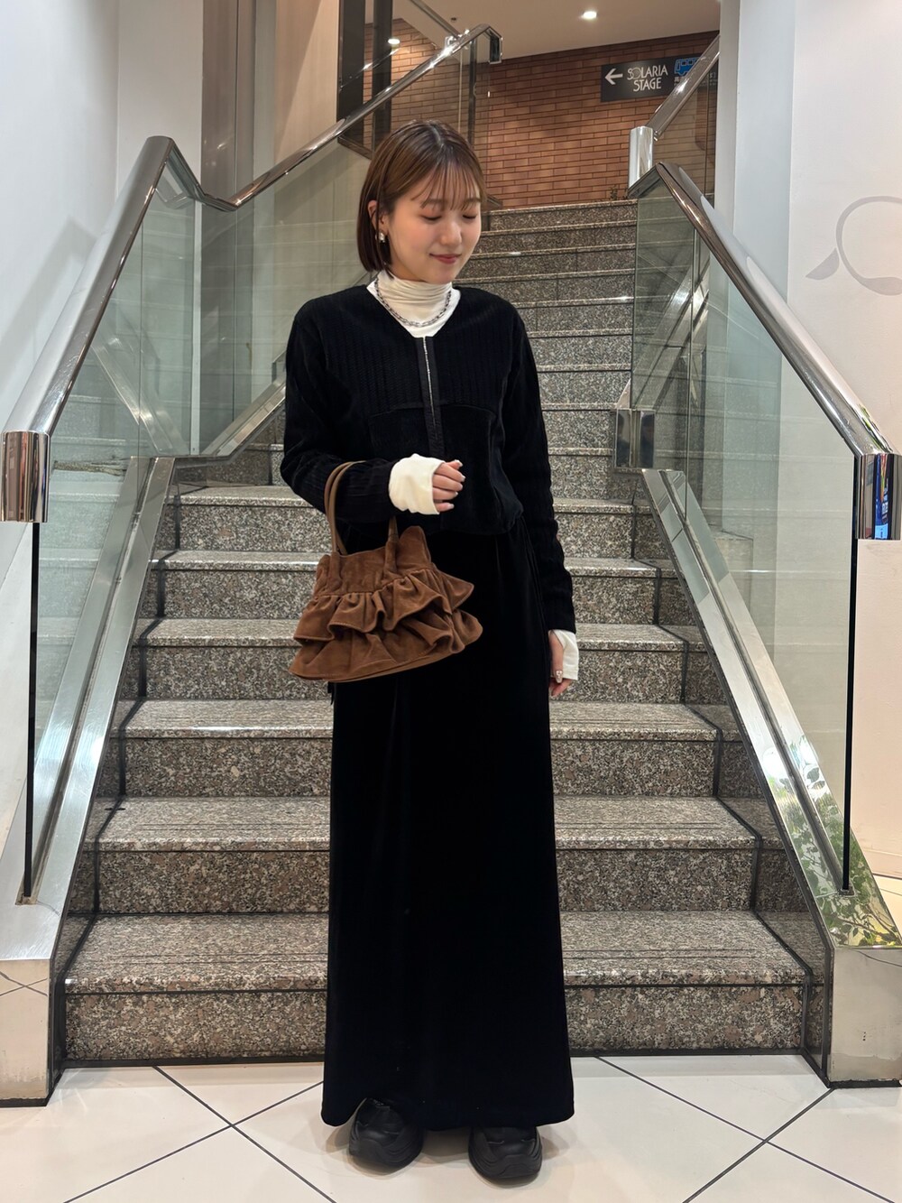 ホワイト系のTシャツ/カットソー、ブラック系のカーディガン/ボレロ、ブラック系のスカートを着用したレディースの冬コーディネートの5枚目の写真