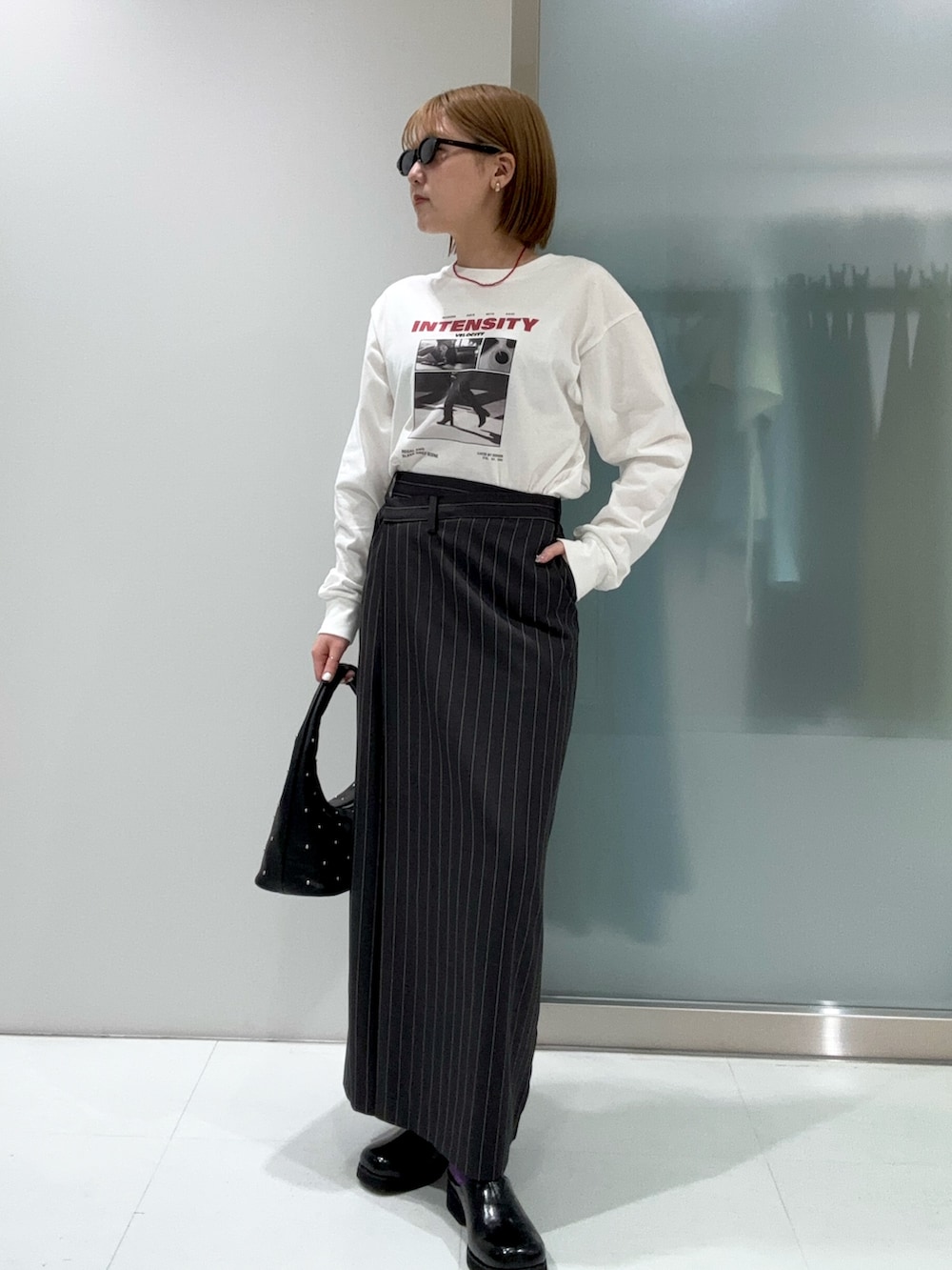 グレー系のスカート、その他のTシャツ/カットソー、ブラック系のハンドバッグを着用したレディースの春コーディネートの4枚目の写真