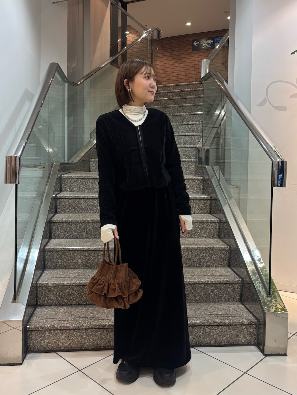 ホワイト系のTシャツ/カットソー、ブラック系のカーディガン/ボレロ、ブラック系のスカートを着用したレディースの冬コーディネートの6枚目の写真