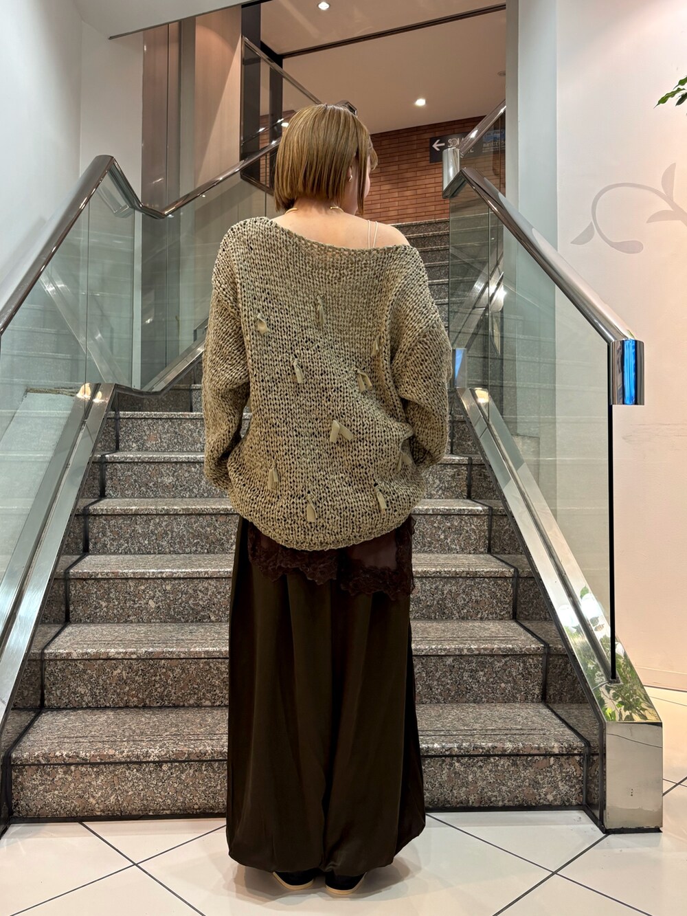 ホワイト系のキャミソール、グリーン系のニット/セーター、ブラウン系のキャミソールを着用したレディースの冬コーディネートの4枚目の写真