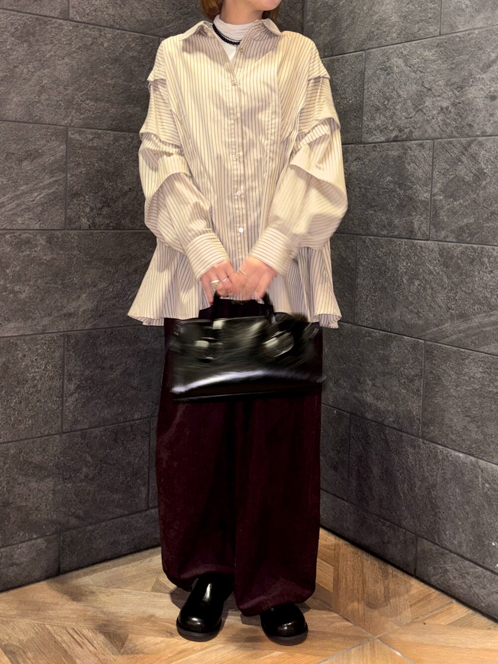 ホワイト系のTシャツ/カットソー、ベージュ系のシャツ/ブラウス、レッド系のその他パンツを着用したレディースの冬コーディネートの5枚目の写真