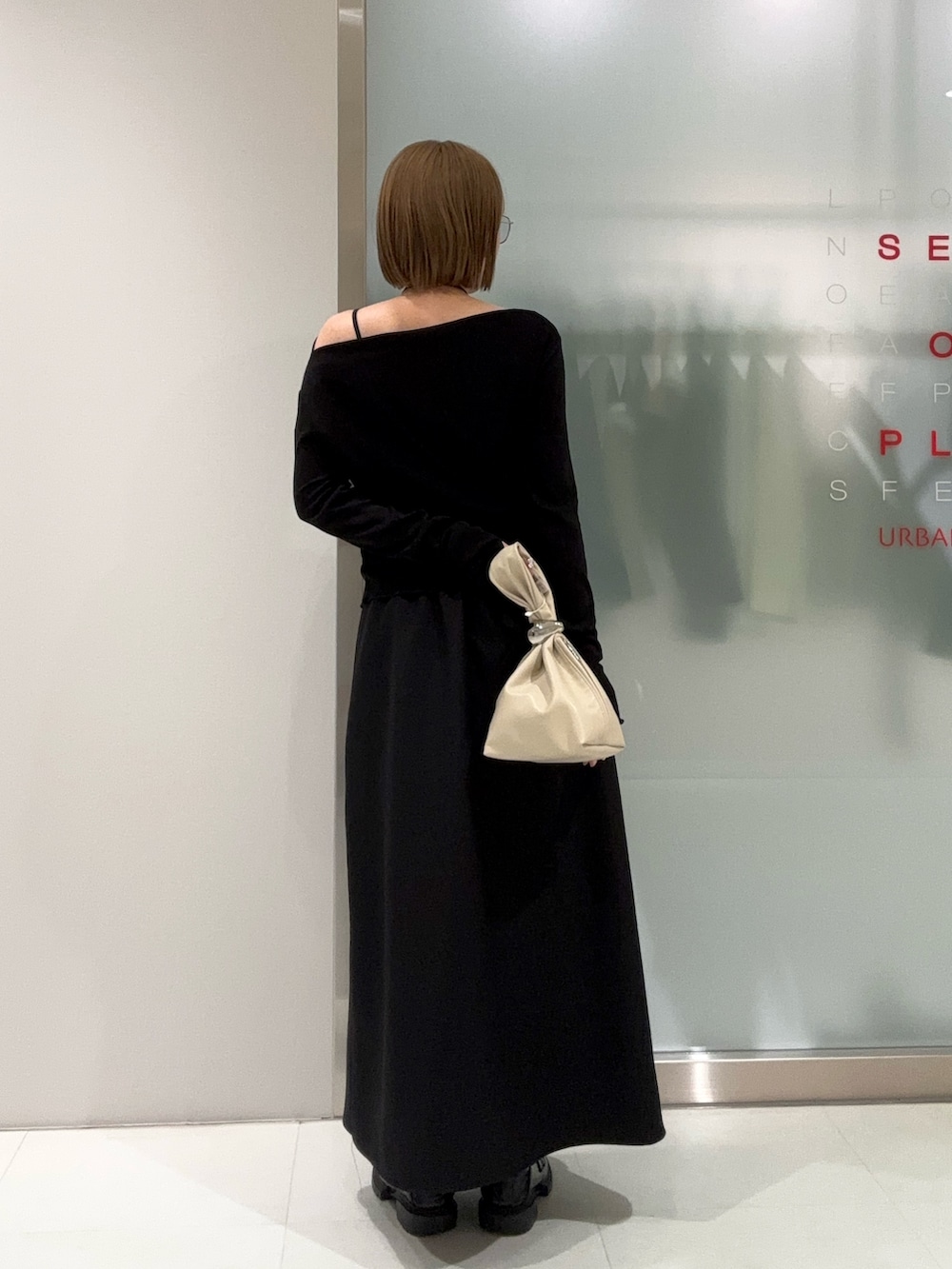 ブラック系のスカート、ベージュ系のハンドバッグ、ブラック系のTシャツ/カットソーを着用したレディースの春コーディネートの5枚目の写真