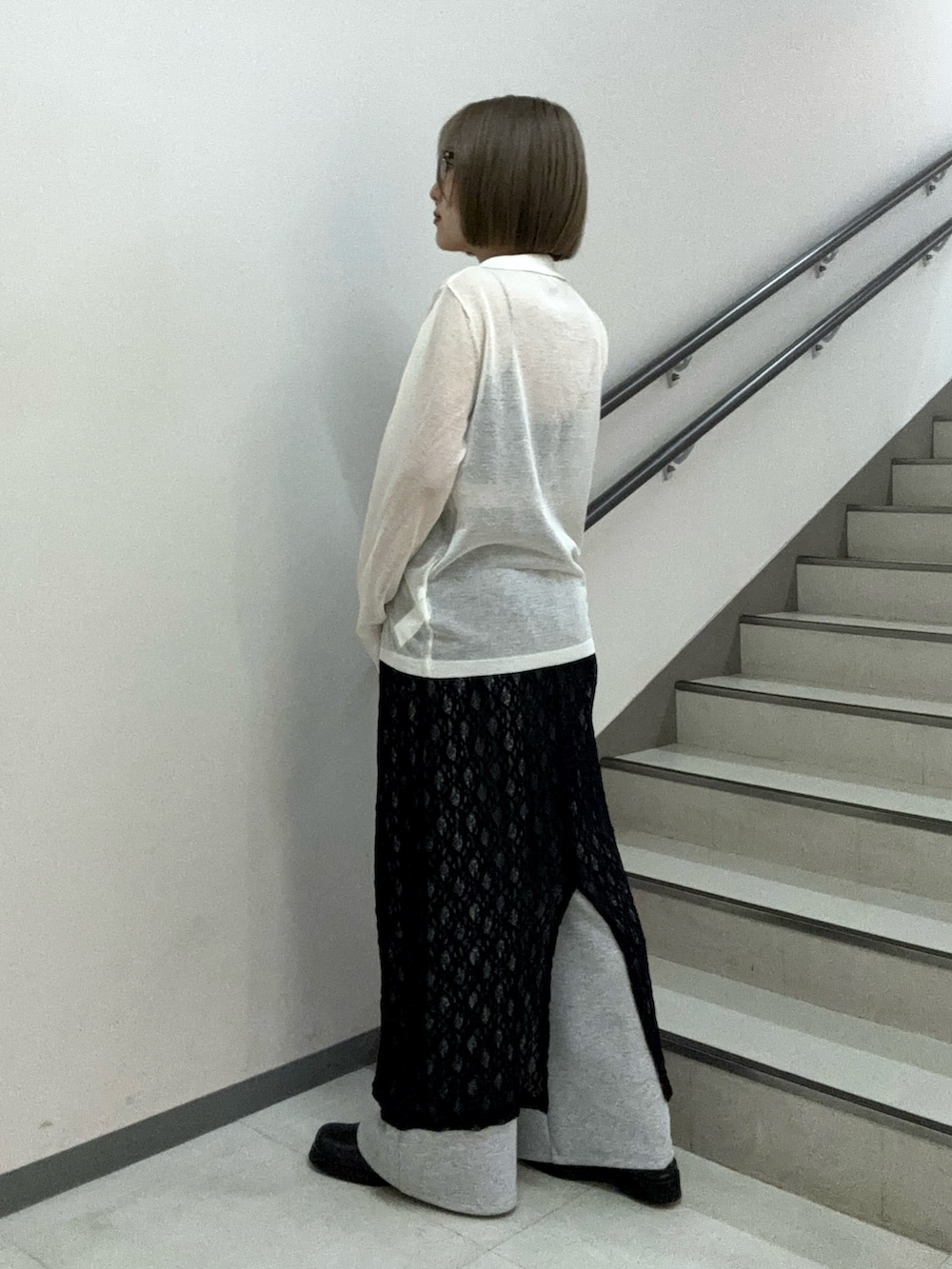 ホワイト系のニット/セーター、ブラック系のキャミソール、ブラック系のスカートを着用したレディースの春コーディネートの4枚目の写真