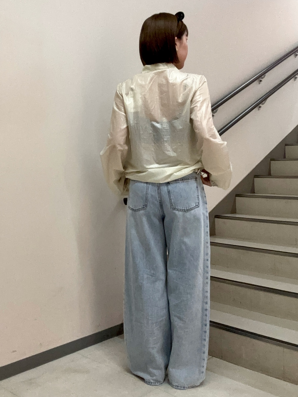 ブルー系のデニムパンツ、ブラック系のキャミソール、ホワイト系のブルゾンを着用したレディースの春コーディネートの4枚目の写真