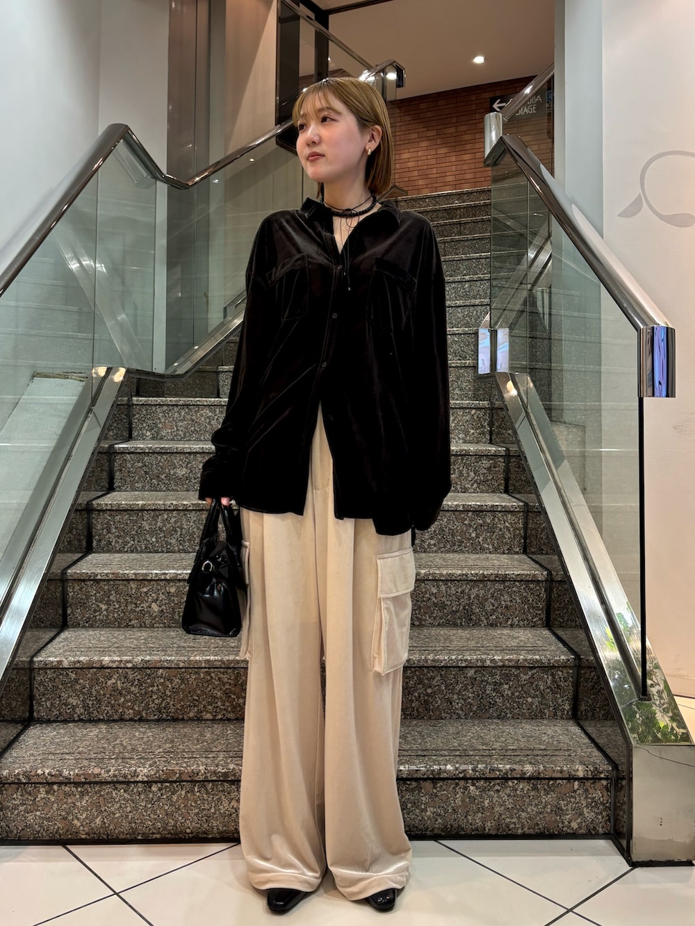 ブラック系のシャツ/ブラウス、ブラック系のボストンバッグ、ベージュ系のその他パンツを着用したレディースの冬コーディネートの2枚目の写真