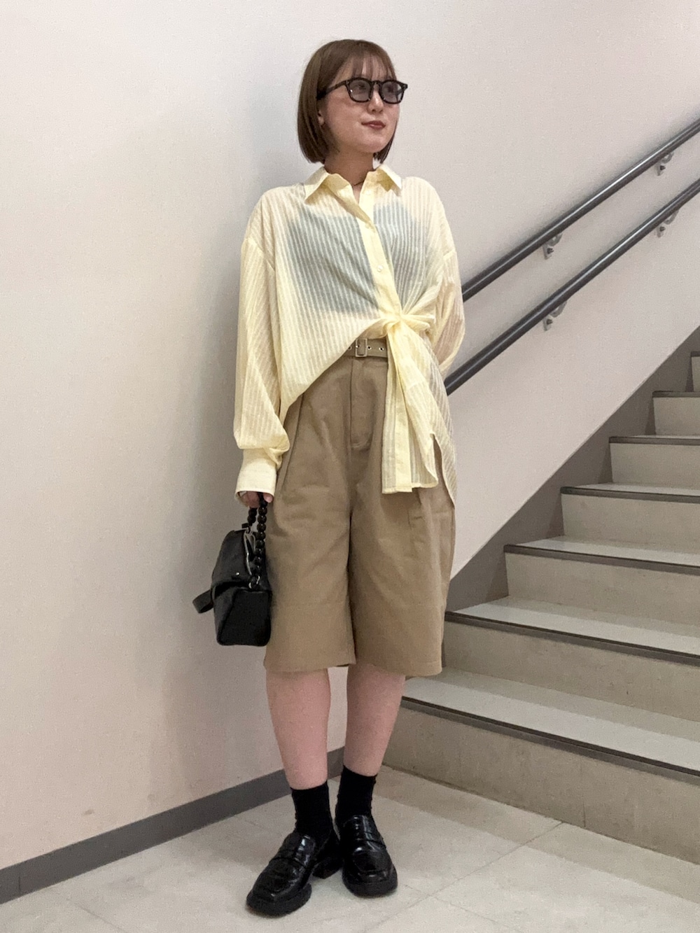 ブラック系のショルダーバッグ、ベージュ系のその他パンツ、イエロー系のシャツ/ブラウスを着用したレディースの夏コーディネートの3枚目の写真