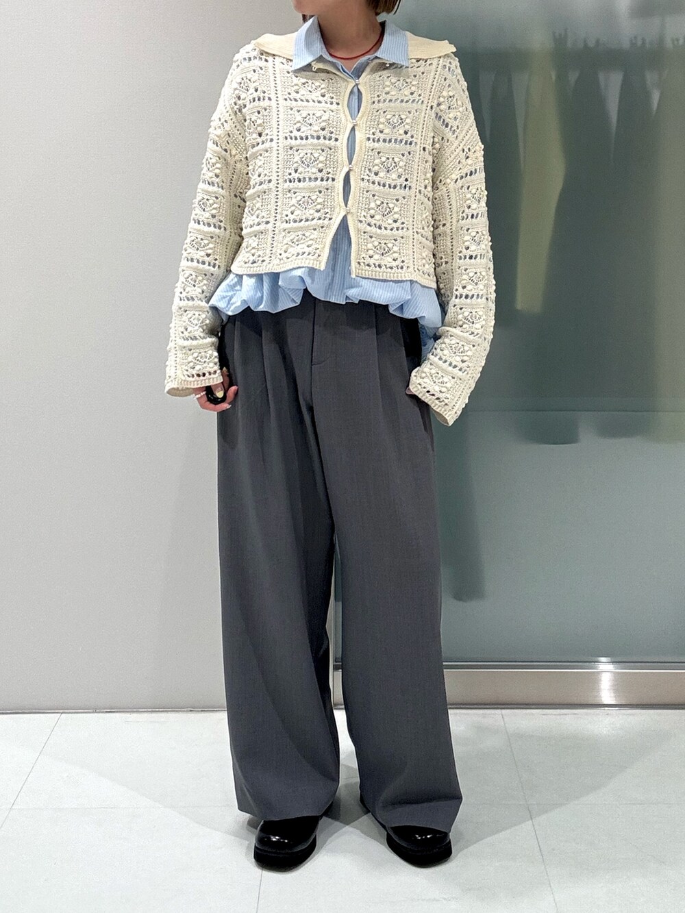 ホワイト系のカーディガン/ボレロ、ブルー系のシャツ/ブラウス、グレー系のスラックスを着用したレディースの春コーディネートの5枚目の写真