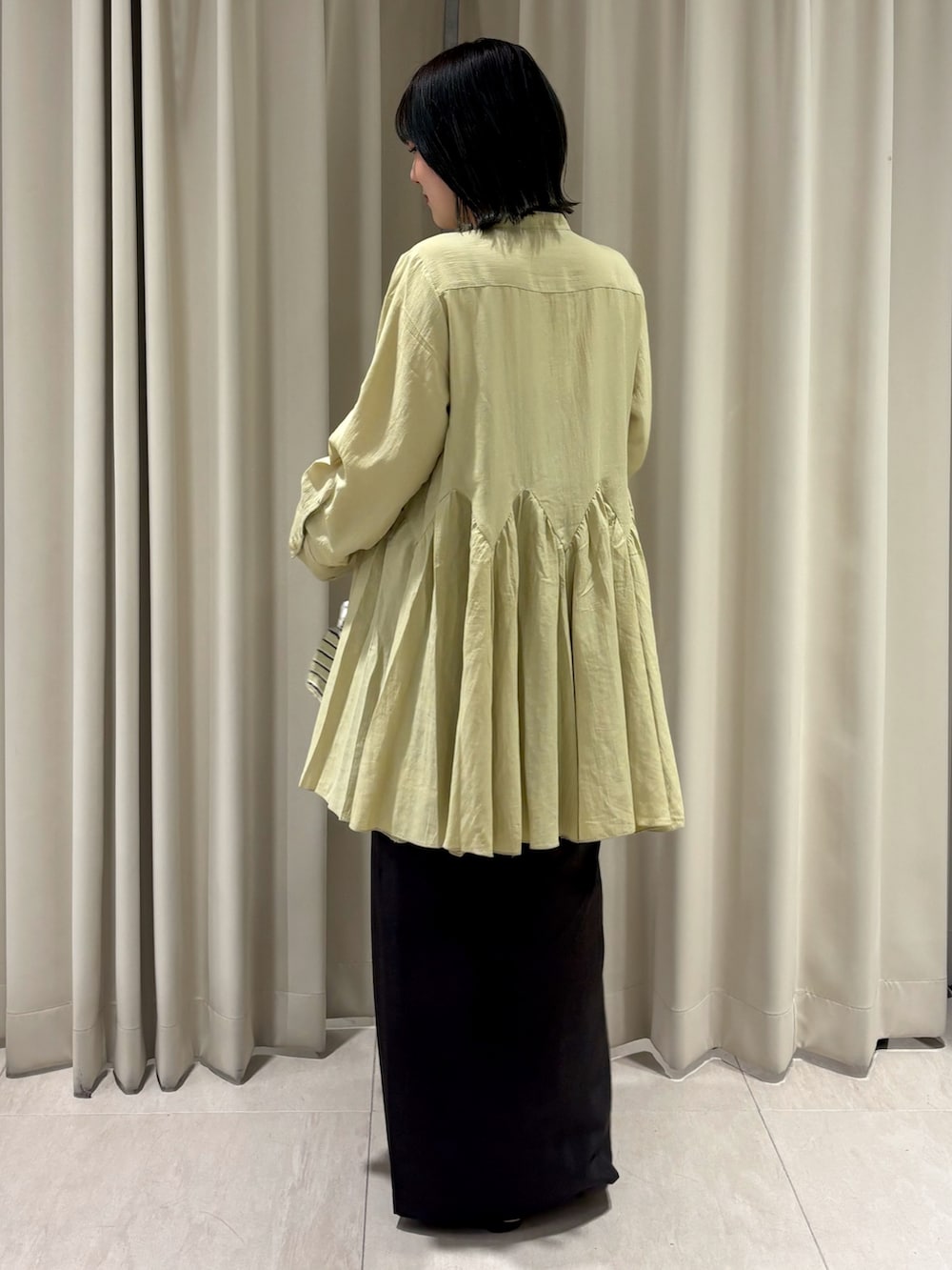 ブラウン系のTシャツ/カットソー、ブラウン系のスカート、ホワイト系のハンドバッグを着用したレディースの秋コーディネートの5枚目の写真