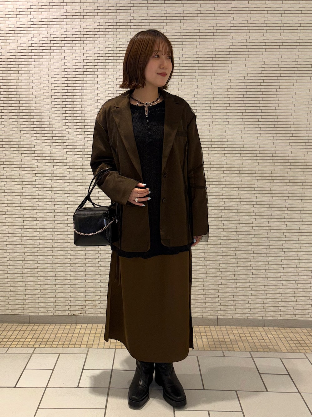 ブラウン系のその他アウター、ブラウン系のワンピース、ブラック系のTシャツ/カットソーを着用したレディースの冬コーディネートの5枚目の写真