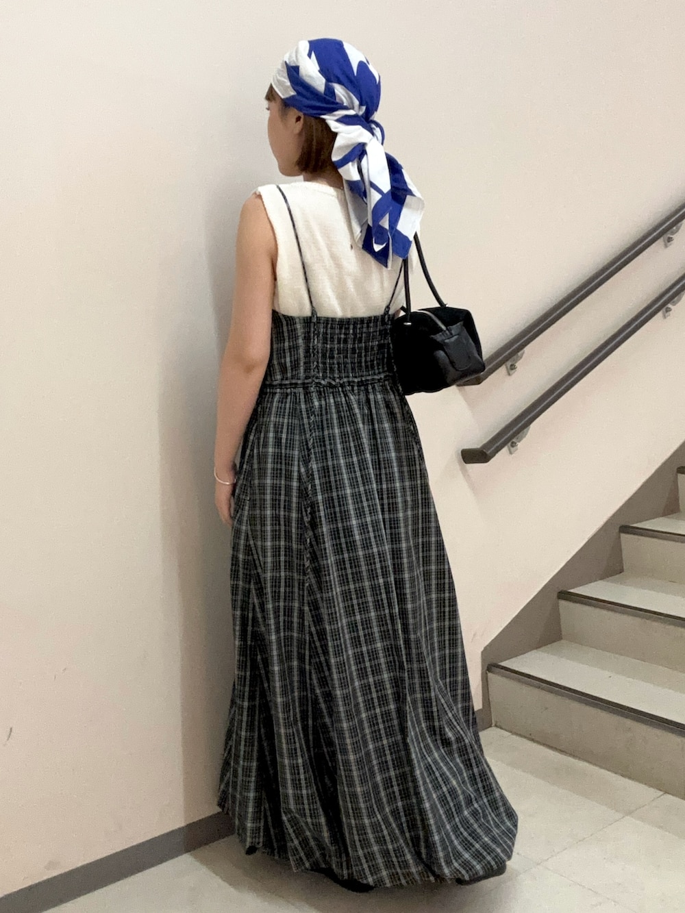 ブラック系のトートバッグ、ブラック系のワンピース、ホワイト系のニット/セーターを着用したレディースの夏コーディネートの4枚目の写真