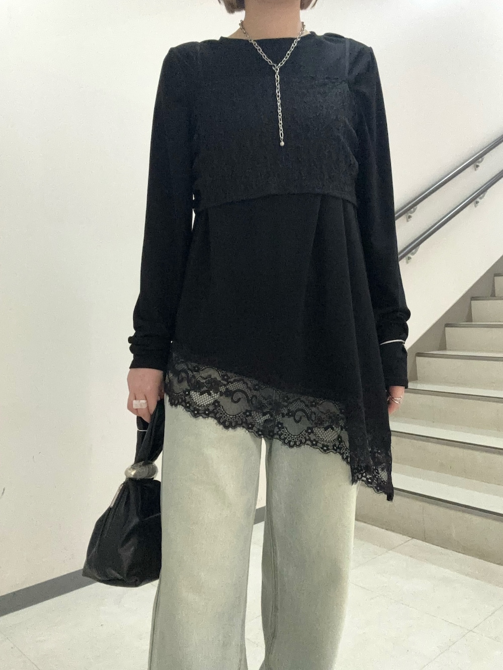 ブラック系のTシャツ/カットソー、ブラック系のハンドバッグ、ブラック系のサンダルを着用したレディースの春コーディネートの4枚目の写真