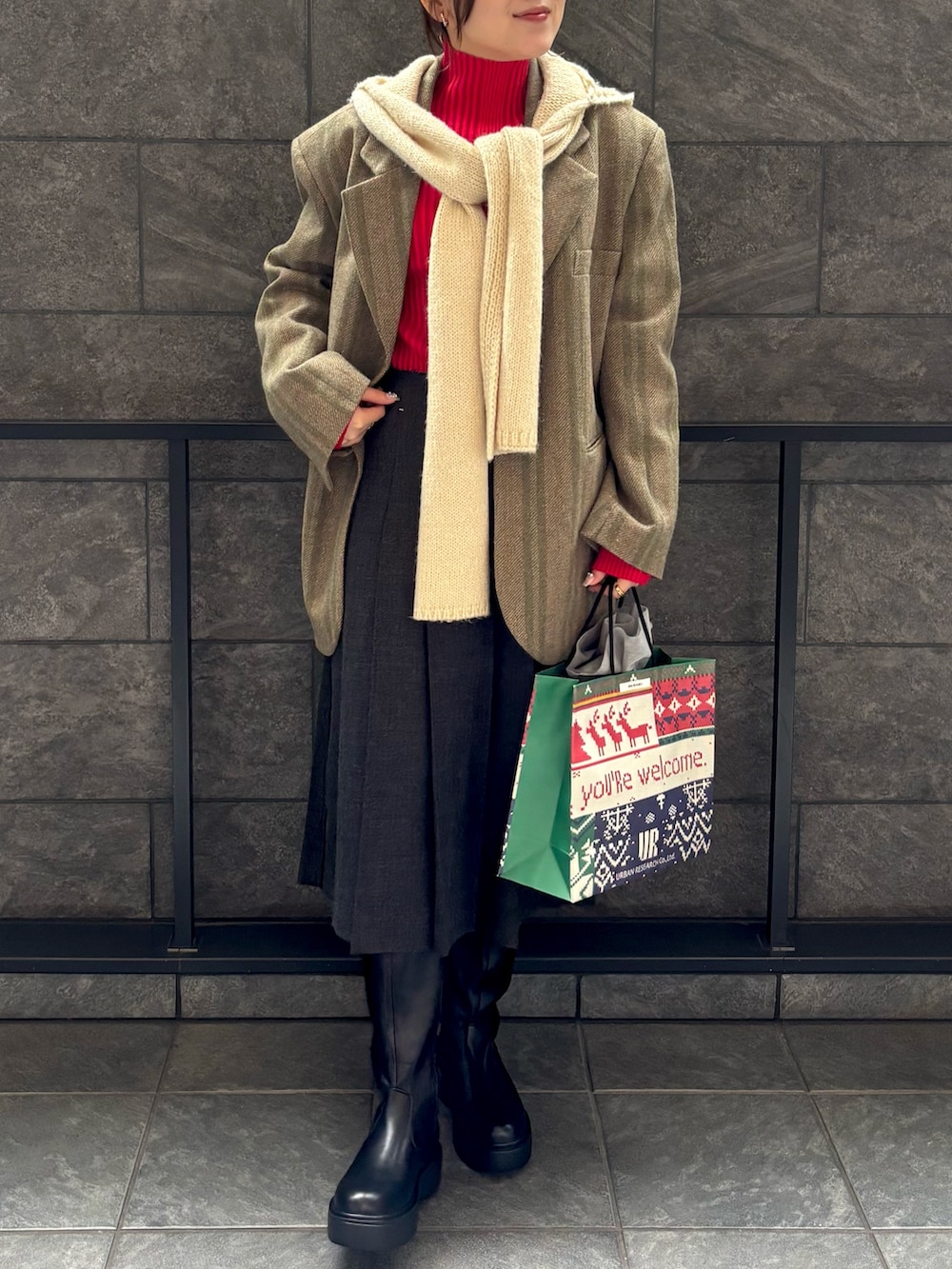 レッド系のニット/セーター、グレー系のスカート、グリーン系のその他アウターを着用したレディースの秋コーディネートの3枚目の写真