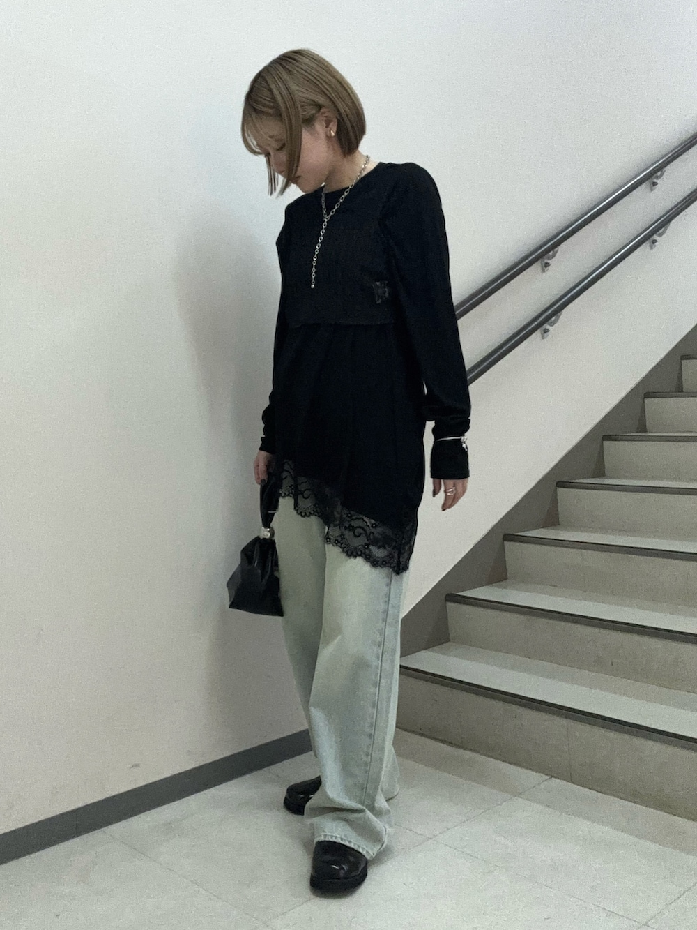 ブラック系のTシャツ/カットソー、ブラック系のハンドバッグ、ブラック系のサンダルを着用したレディースの春コーディネートの3枚目の写真