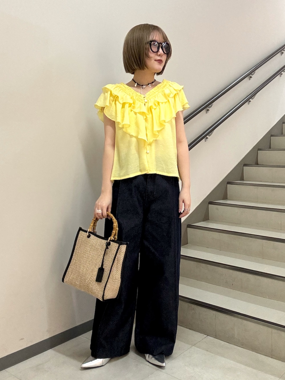 イエロー系のシャツ/ブラウス、シルバー系のパンプス、ブラック系のショルダーバッグを着用したレディースの春コーディネートの5枚目の写真