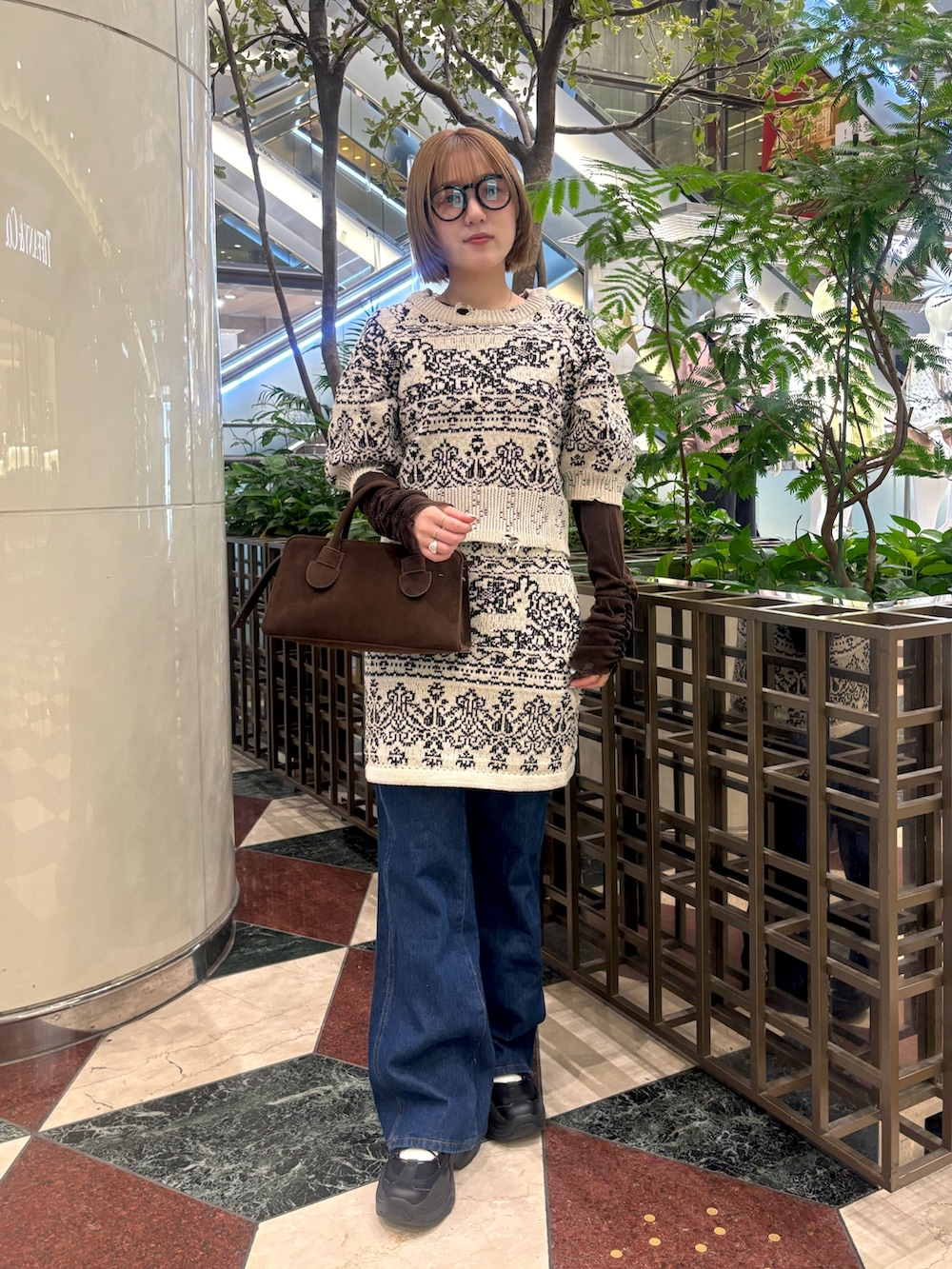 ベージュ系のニット/セーター、ベージュ系のスカート、ブルー系のデニムパンツを着用したレディースの冬コーディネートの3枚目の写真