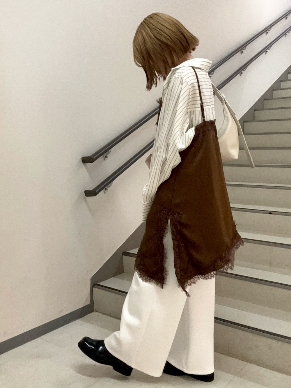 ホワイト系のその他パンツ、ベージュ系のハンドバッグ、ブラウン系のキャミソールを着用したレディースの春コーディネートの5枚目の写真