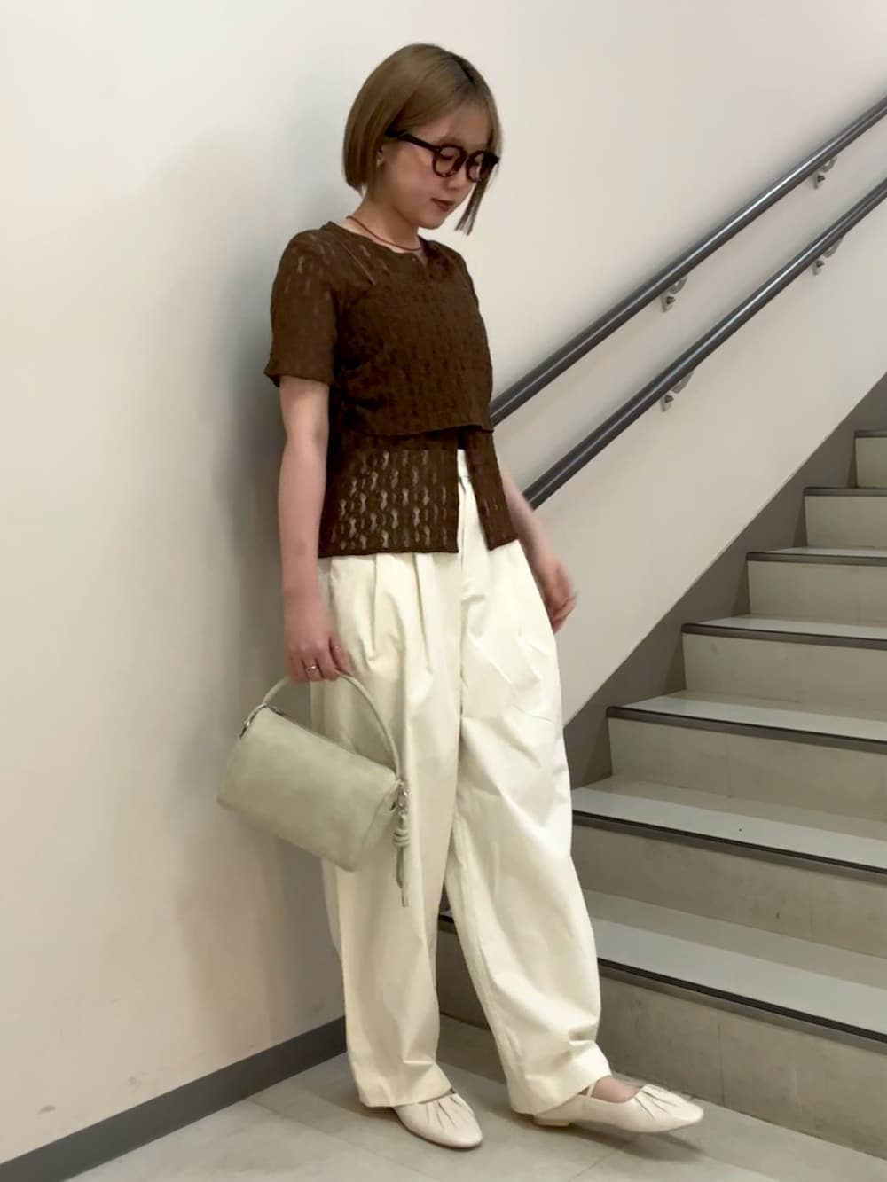 ブラウン系のTシャツ/カットソー、ホワイト系のその他パンツ、ベージュ系のハンドバッグを着用したレディースの春コーディネートの4枚目の写真