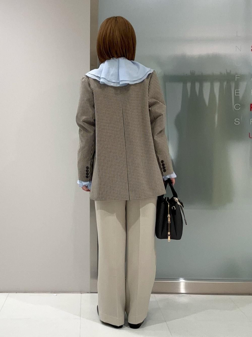 ブラック系のハンドバッグ、ベージュ系のその他パンツ、ブラック系のローファーを着用したレディースの春コーディネートの4枚目の写真