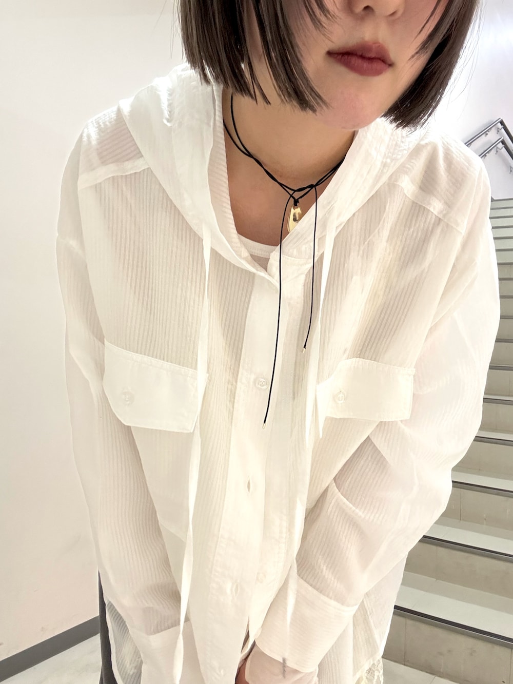 グレー系のスラックス、ブラック系のショルダーバッグ、ホワイト系のシャツ/ブラウスを着用したレディースの春コーディネートの6枚目の写真