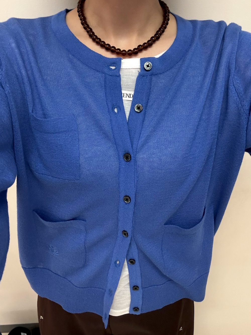ブルー系のカーディガン/ボレロ、ホワイト系のTシャツ/カットソー、ブラック系のパンプスを着用したレディースの春コーディネートの5枚目の写真