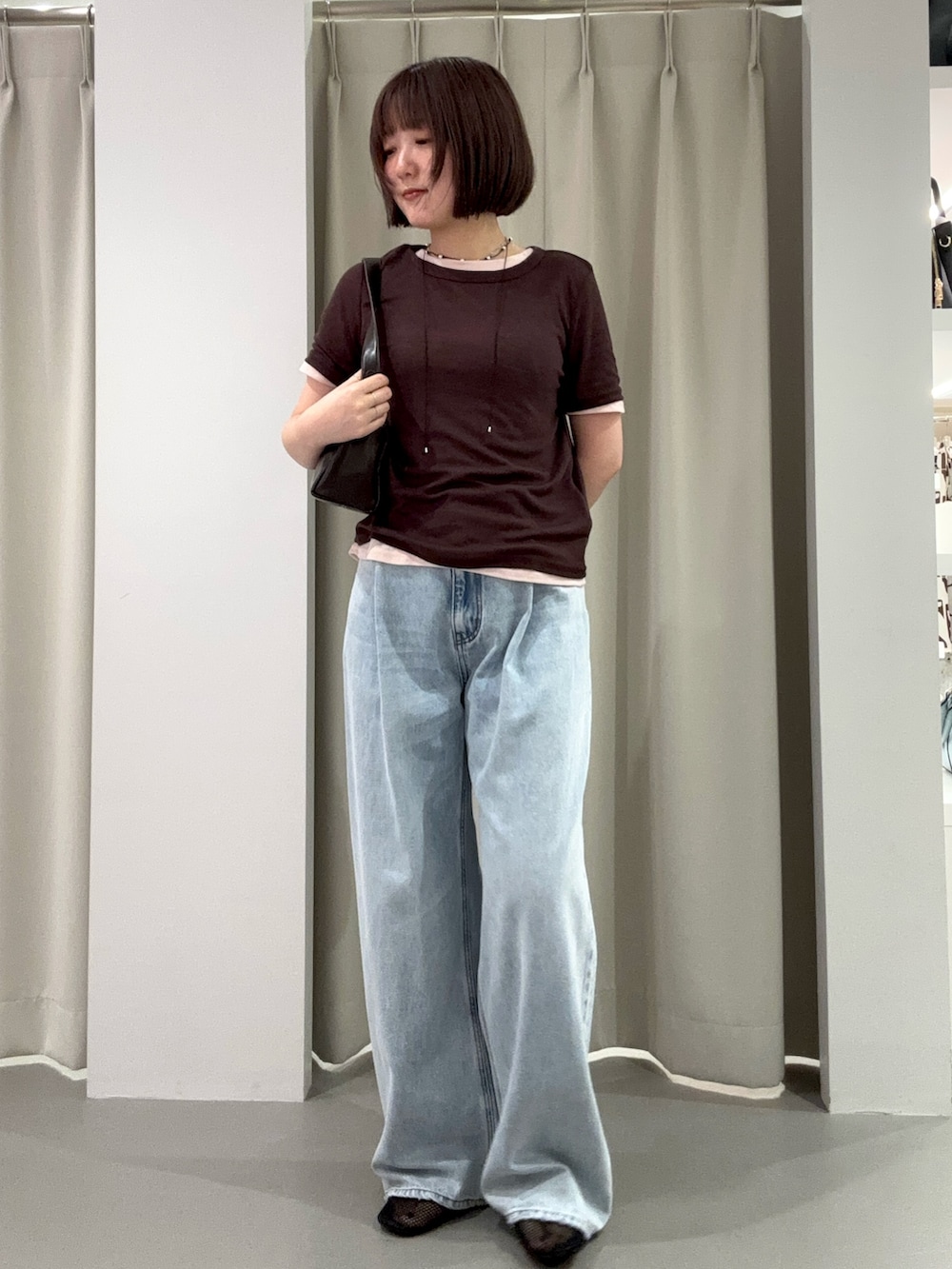 ブルー系のデニムパンツ、ブラウン系のショルダーバッグ、ブラック系のパンプスを着用したレディースの夏コーディネートの2枚目の写真