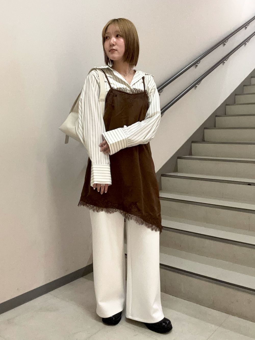 ホワイト系のその他パンツ、ベージュ系のハンドバッグ、ブラウン系のキャミソールを着用したレディースの春コーディネートの2枚目の写真