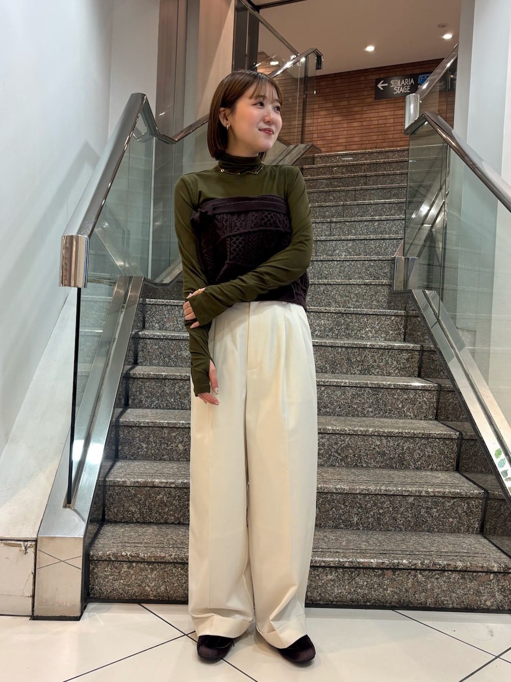 グリーン系のTシャツ/カットソー、ブラウン系のスカート、ホワイト系のその他パンツを着用したレディースの冬コーディネートの3枚目の写真