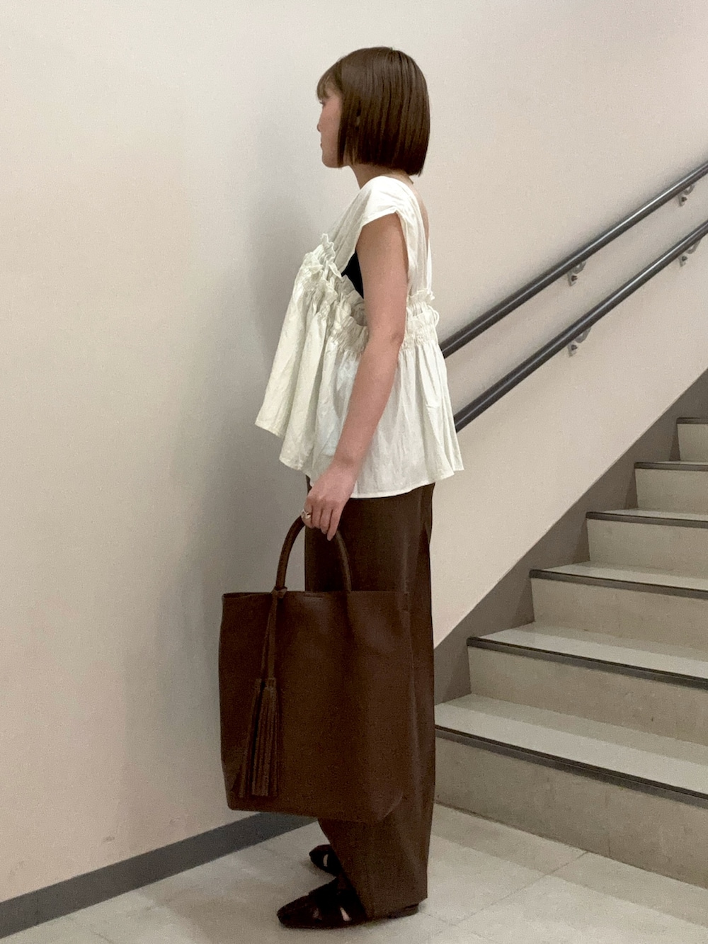ブラウン系のその他パンツ、ブラウン系のサンダル、ホワイト系のシャツ/ブラウスを着用したレディースの夏コーディネートの3枚目の写真