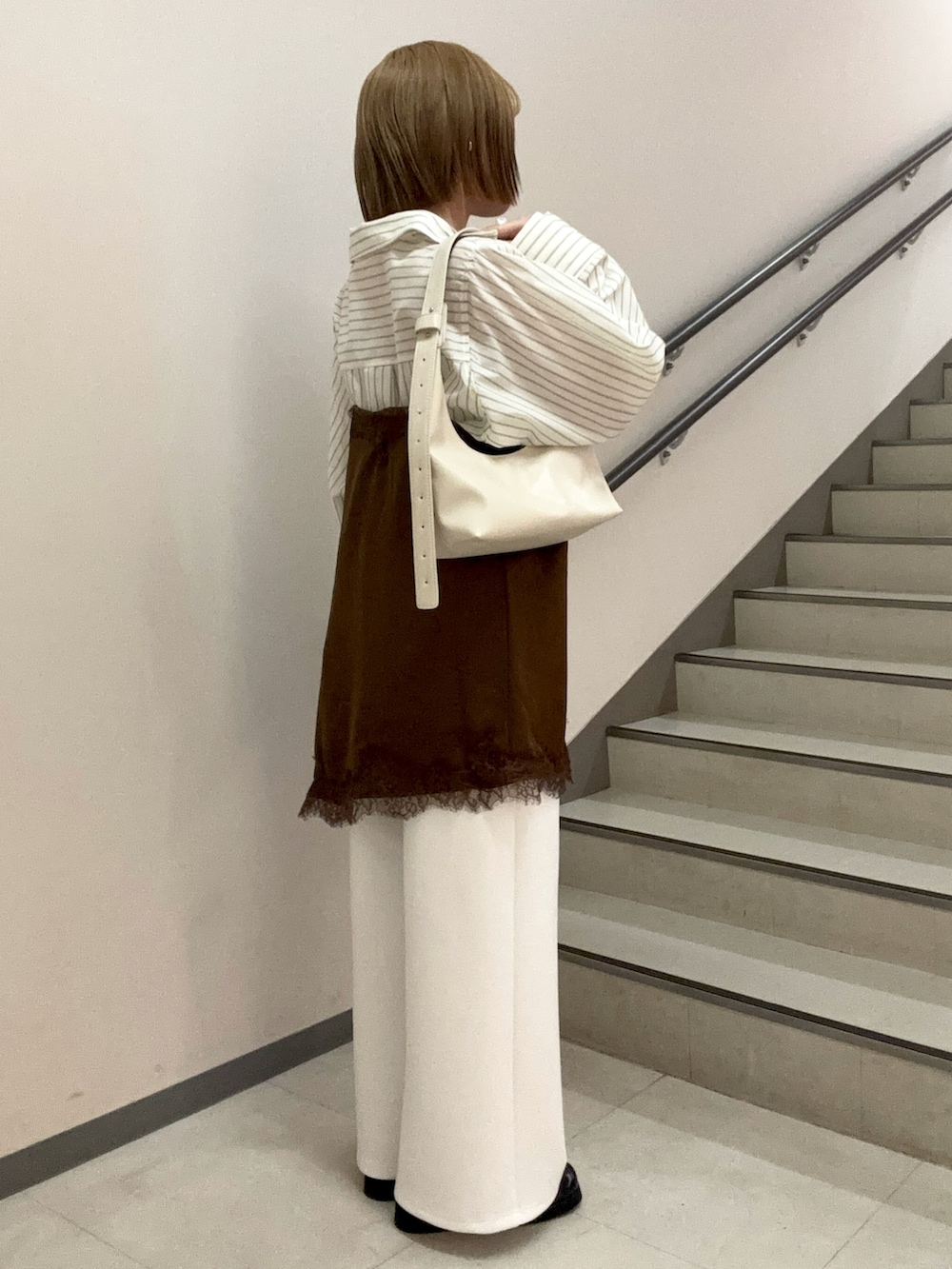 ホワイト系のその他パンツ、ベージュ系のハンドバッグ、ブラウン系のキャミソールを着用したレディースの春コーディネートの3枚目の写真