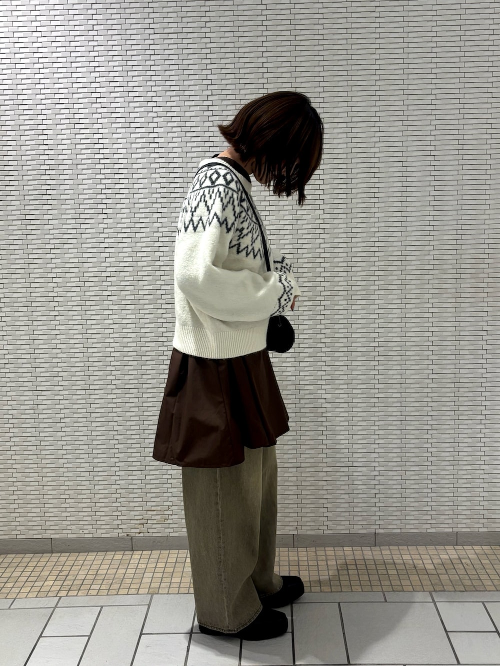 ホワイト系のニット/セーター、グリーン系のデニムパンツ、ブラウン系のワンピースを着用したレディースの冬コーディネートの5枚目の写真