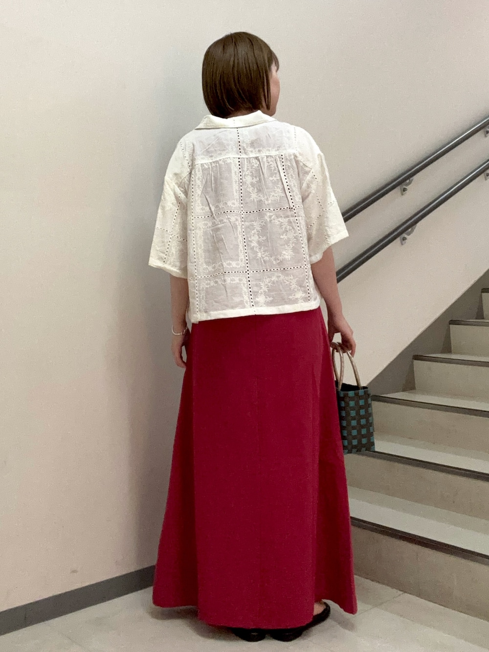 レッド系のワンピース、ブラック系のサンダル、ブラウン系のショルダーバッグを着用したレディースの夏コーディネートの3枚目の写真