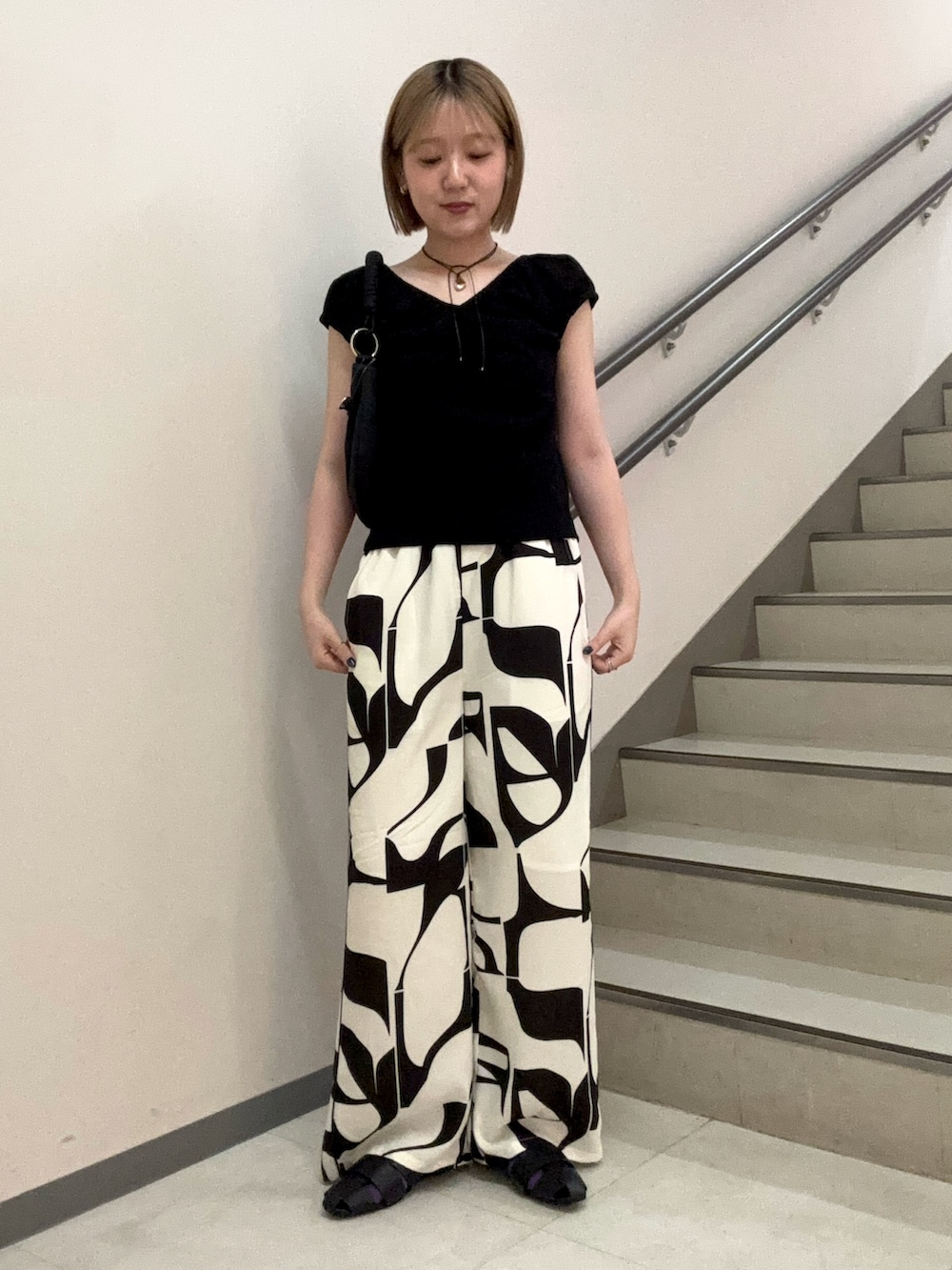ブラック系のその他パンツ、ブラック系のサンダル、ブラック系のハンドバッグを着用したレディースの春コーディネートの3枚目の写真