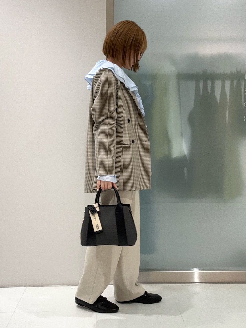 ブラック系のハンドバッグ、ベージュ系のその他パンツ、ブラック系のローファーを着用したレディースの春コーディネートの3枚目の写真